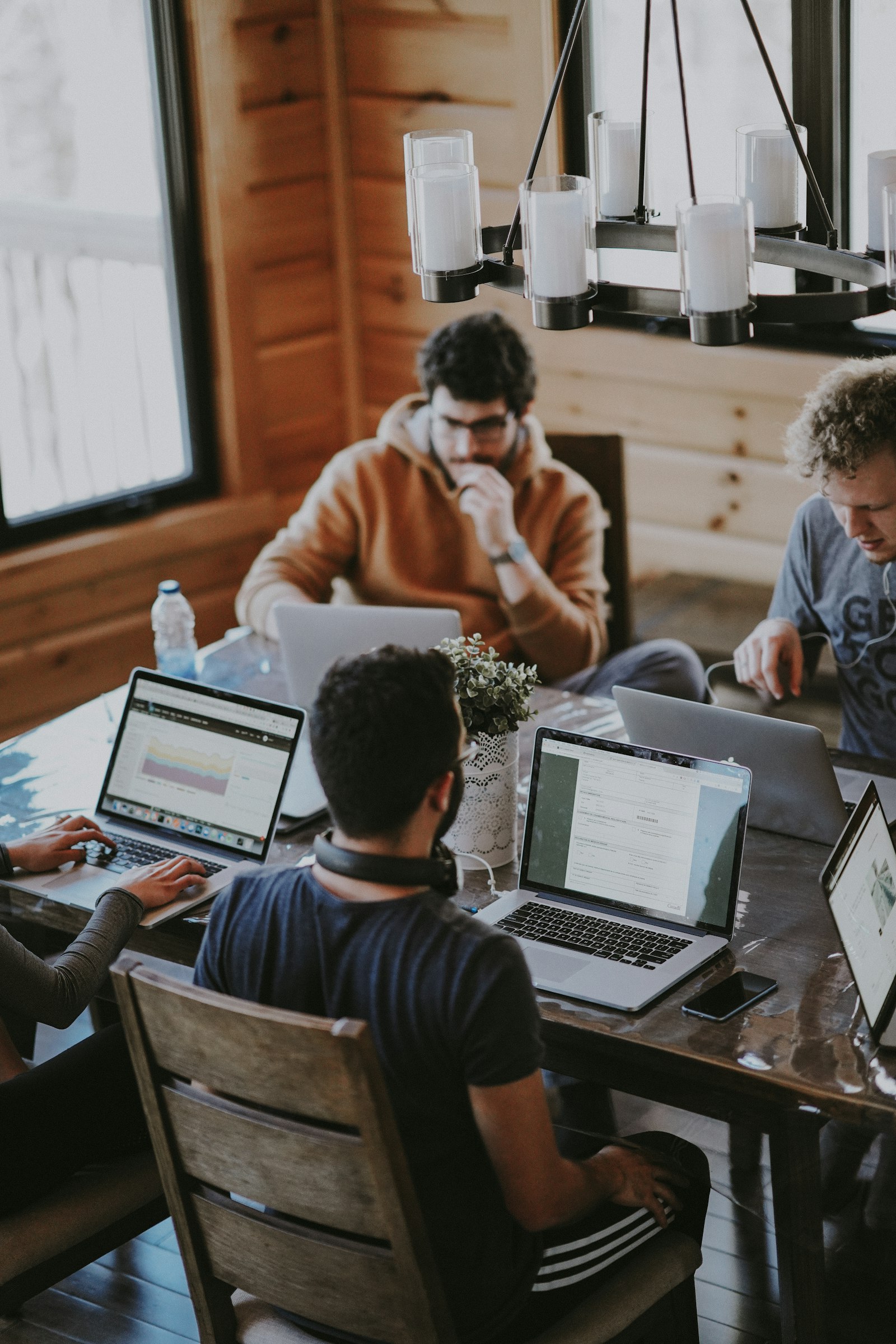 A team working around a shared table with laptops